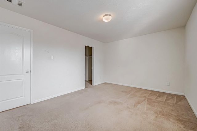 spare room featuring carpet floors, baseboards, and visible vents