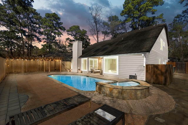 view of pool featuring a patio area, a fenced backyard, and a pool with connected hot tub