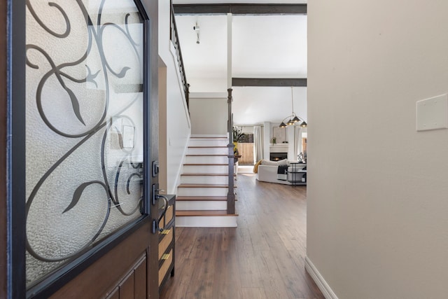 foyer entrance featuring dark wood-style floors, baseboards, and stairs