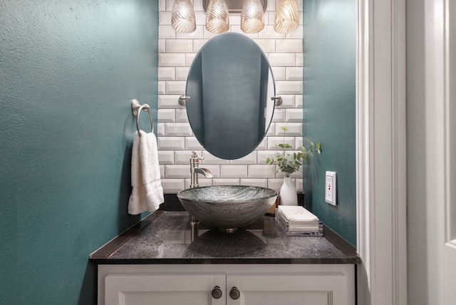 bathroom featuring vanity, backsplash, and a textured wall