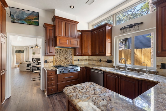 kitchen featuring visible vents, appliances with stainless steel finishes, dark wood-type flooring, light stone countertops, and a sink