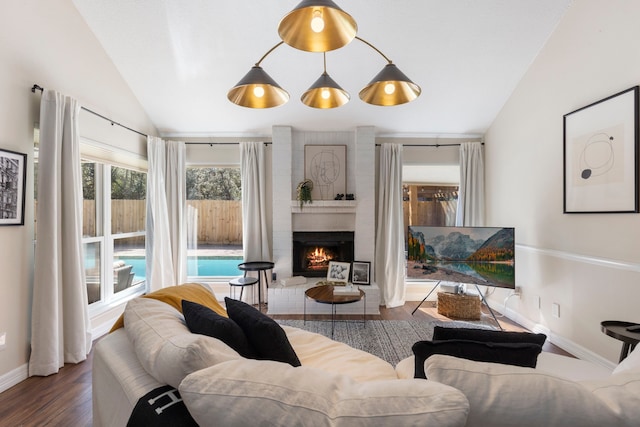 living room with lofted ceiling, a fireplace, baseboards, and wood finished floors