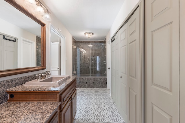 full bathroom with a stall shower, vanity, a closet, and tile patterned floors