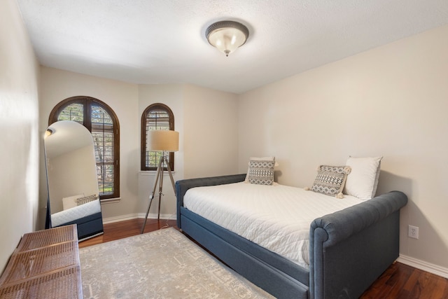 bedroom featuring baseboards and wood finished floors