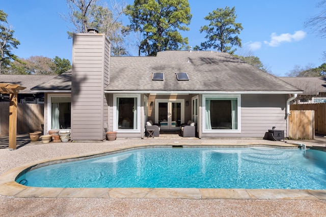 rear view of house with a patio, a shingled roof, fence, french doors, and a fenced in pool