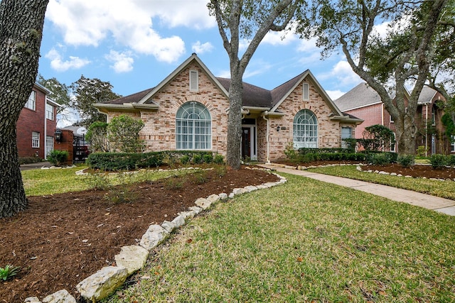 traditional home featuring brick siding and a front lawn