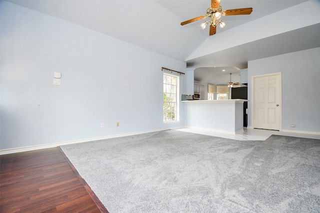 unfurnished living room with light wood-style flooring, baseboards, high vaulted ceiling, and ceiling fan