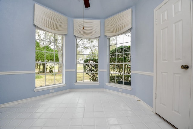 interior space with baseboards and ceiling fan