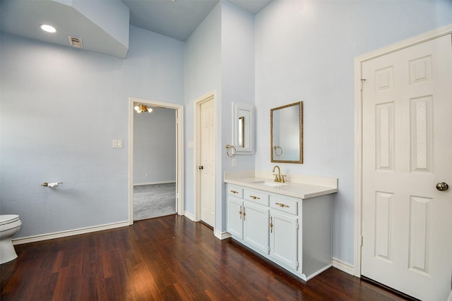 bathroom with visible vents, toilet, baseboards, and wood finished floors