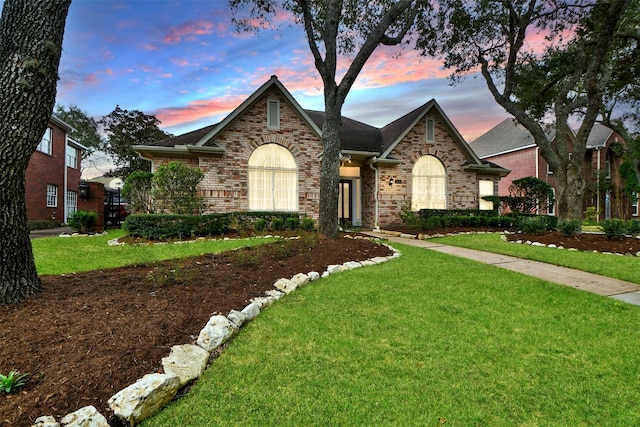 view of front of home featuring brick siding and a front yard