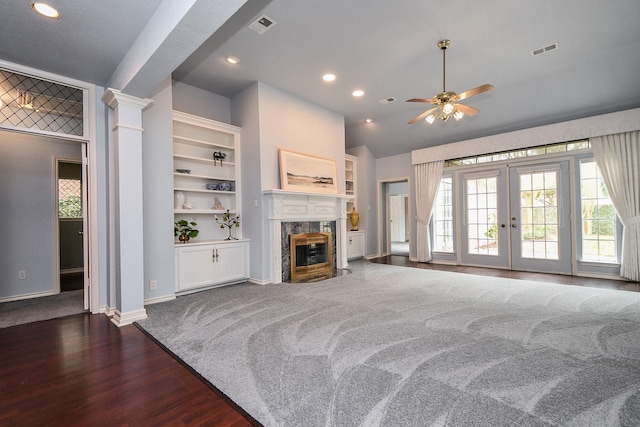 living area featuring decorative columns, french doors, visible vents, and a high end fireplace