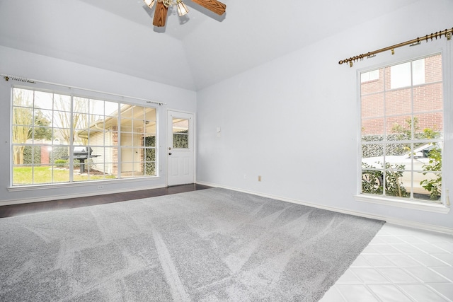 unfurnished room with lofted ceiling, plenty of natural light, and baseboards