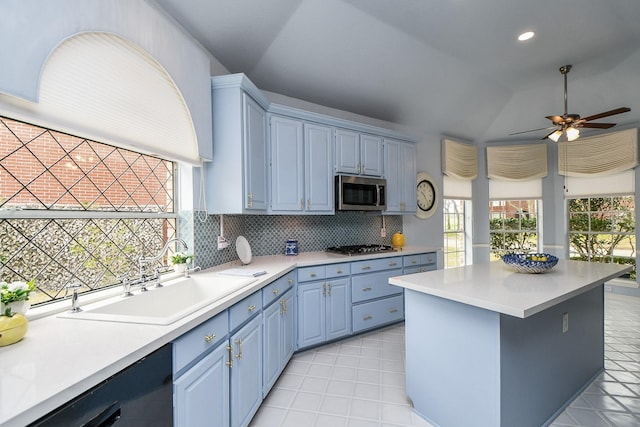 kitchen featuring blue cabinetry, a sink, decorative backsplash, light countertops, and appliances with stainless steel finishes