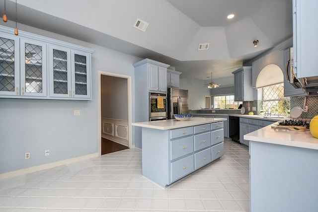 kitchen featuring a center island, visible vents, stainless steel appliances, and vaulted ceiling