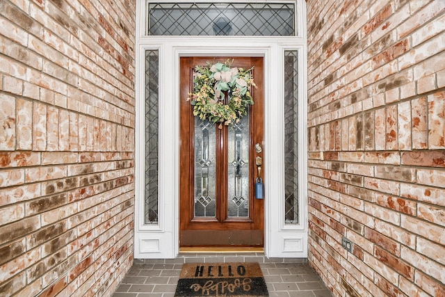 doorway to property featuring brick siding