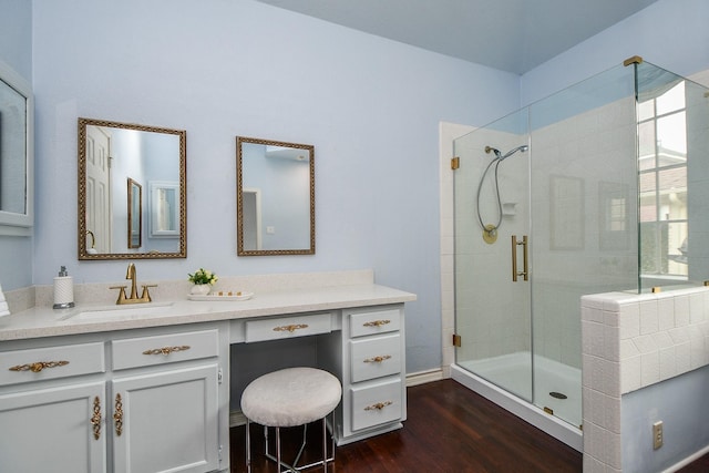 bathroom with a stall shower, vanity, and wood finished floors