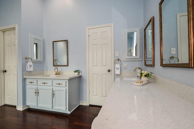 bathroom with baseboards, wood finished floors, and vanity