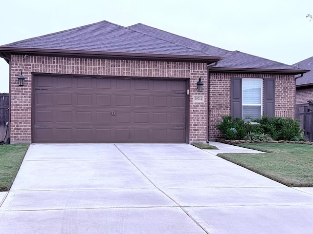 single story home featuring a shingled roof, concrete driveway, brick siding, and an attached garage