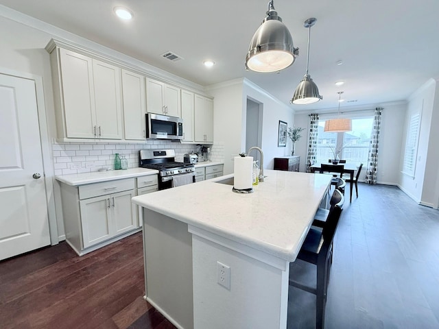 kitchen with stainless steel appliances, visible vents, a sink, and crown molding