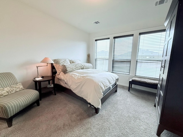 carpeted bedroom with lofted ceiling, visible vents, and baseboards