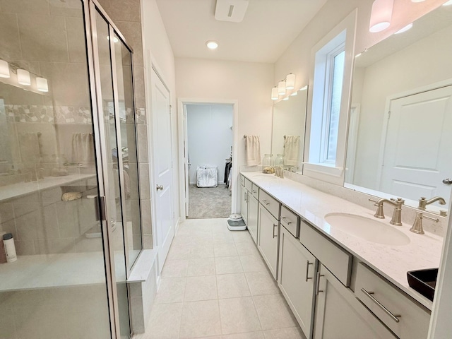 full bathroom featuring a stall shower, tile patterned floors, a sink, and double vanity