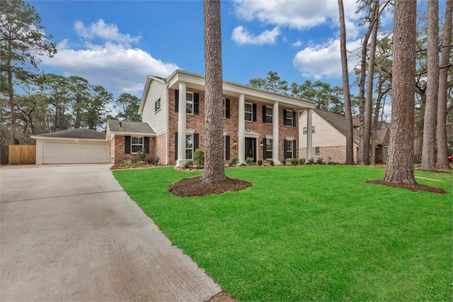 neoclassical home with concrete driveway, fence, a front lawn, and brick siding
