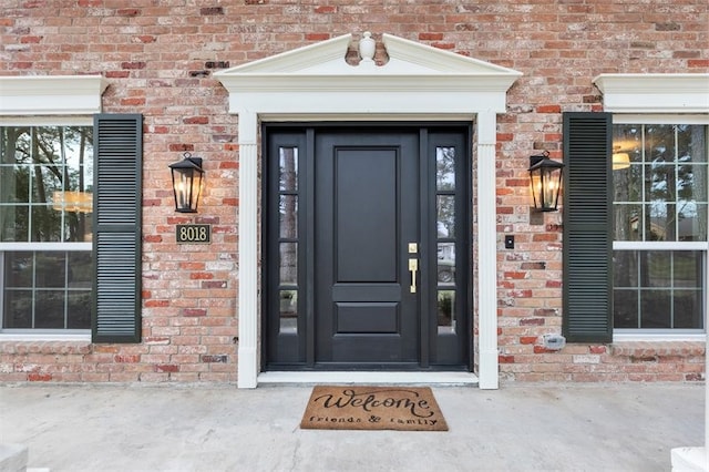 view of exterior entry with brick siding