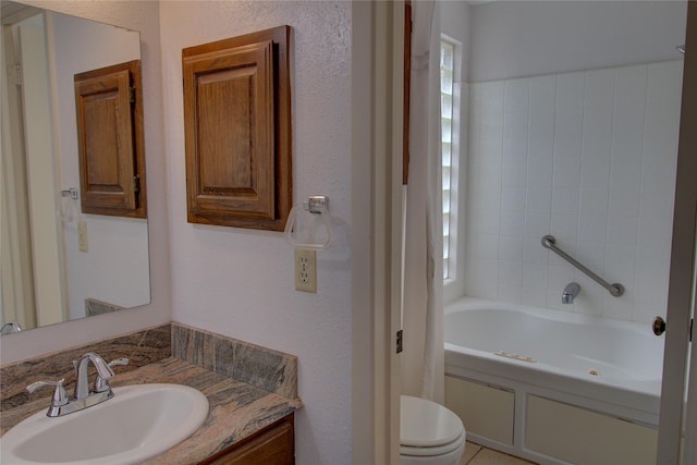 full bath featuring a textured wall, vanity, toilet, and a tub