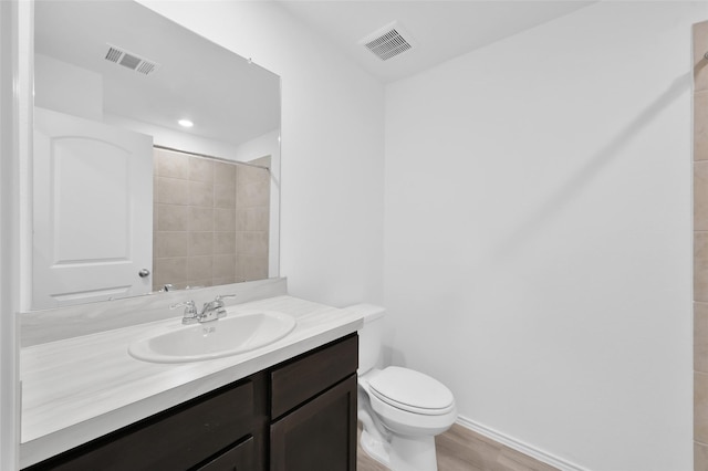 full bath featuring toilet, vanity, visible vents, and baseboards