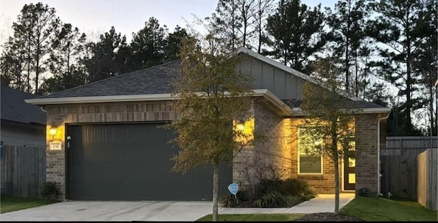 view of home's exterior featuring a garage, driveway, board and batten siding, and fence