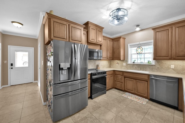 kitchen featuring a sink, backsplash, appliances with stainless steel finishes, and crown molding