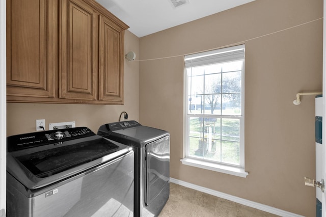 laundry area with cabinet space, baseboards, a wealth of natural light, and washing machine and clothes dryer