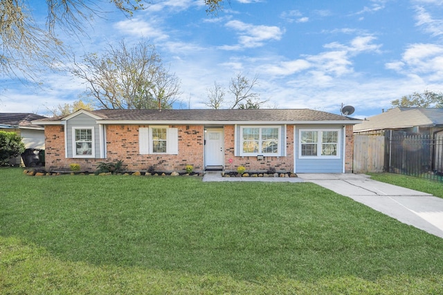 single story home with a front yard, brick siding, fence, and driveway