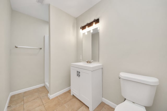 bathroom featuring baseboards, vanity, toilet, and tile patterned floors