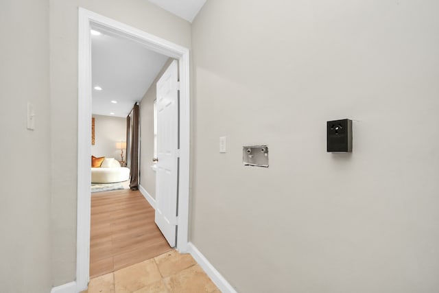 corridor featuring light tile patterned floors, recessed lighting, and baseboards