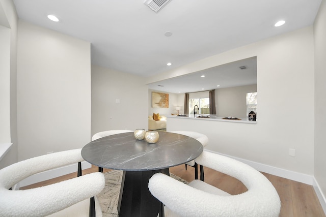 dining room with recessed lighting, baseboards, visible vents, and light wood finished floors