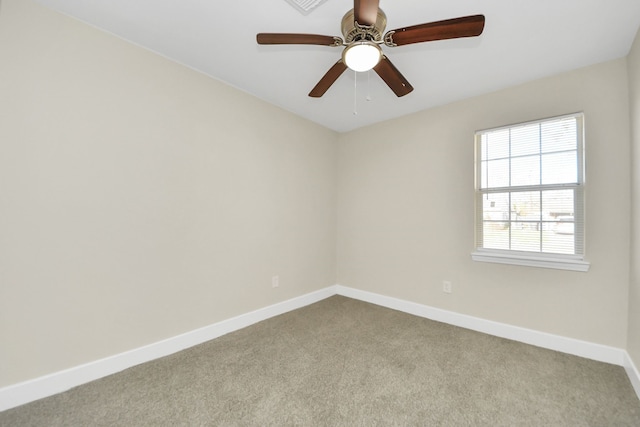 carpeted spare room with ceiling fan and baseboards