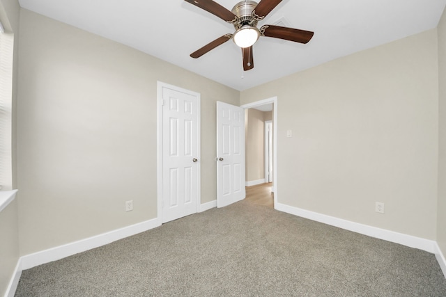 unfurnished bedroom featuring carpet floors, a closet, baseboards, and a ceiling fan