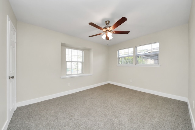 carpeted empty room with ceiling fan and baseboards