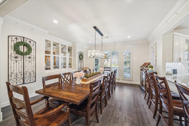 dining space featuring a chandelier, dark wood finished floors, crown molding, and baseboards