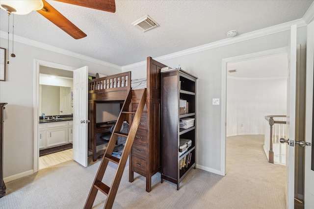 bedroom with light carpet, visible vents, a textured ceiling, and ornamental molding