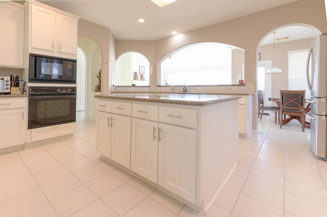 kitchen with backsplash, black appliances, and light tile patterned floors