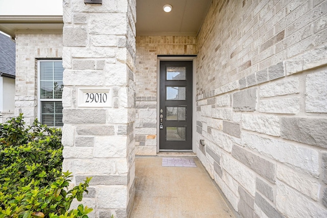 property entrance featuring stone siding