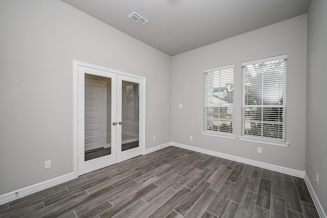 unfurnished room with baseboards, french doors, visible vents, and wood tiled floor