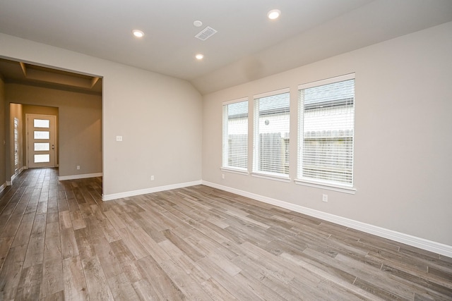 spare room with baseboards, visible vents, wood finished floors, vaulted ceiling, and recessed lighting