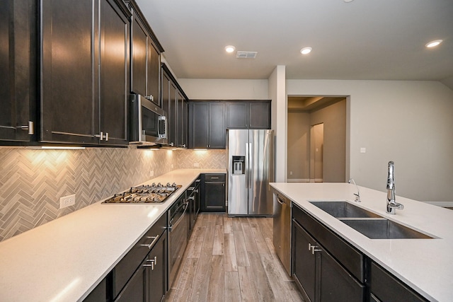 kitchen featuring light countertops, visible vents, appliances with stainless steel finishes, a sink, and light wood-type flooring