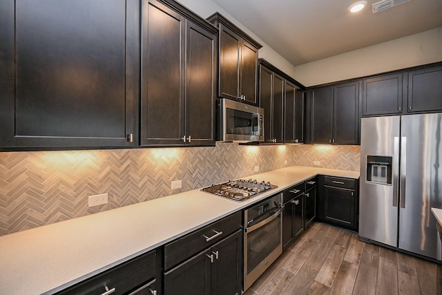 kitchen featuring wood finished floors, visible vents, light countertops, appliances with stainless steel finishes, and tasteful backsplash