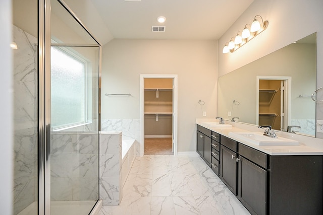 bathroom featuring marble finish floor, a marble finish shower, a sink, and visible vents