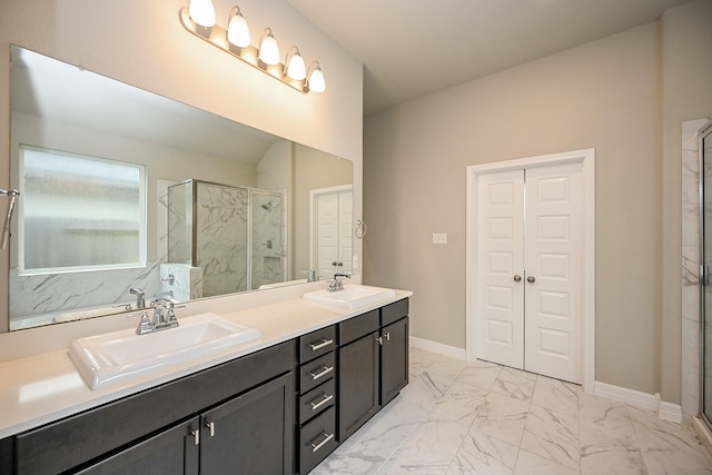 bathroom featuring marble finish floor, baseboards, a sink, and a stall shower