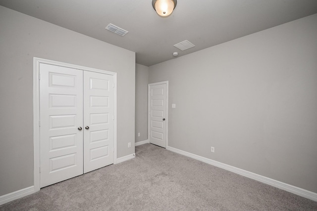 unfurnished bedroom featuring carpet floors, baseboards, visible vents, and a closet